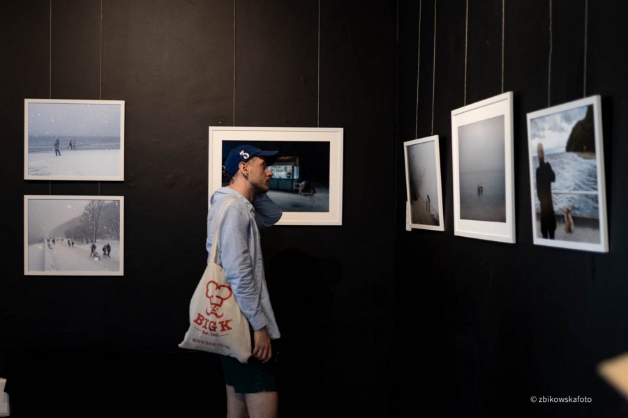 Mężczyzna na tle zdjęć podczas wernisażu wystawy &bdquo;Gdynia Gł&oacute;wna&rdquo; w Galerii Gdyńskiego Centrum Filmowego