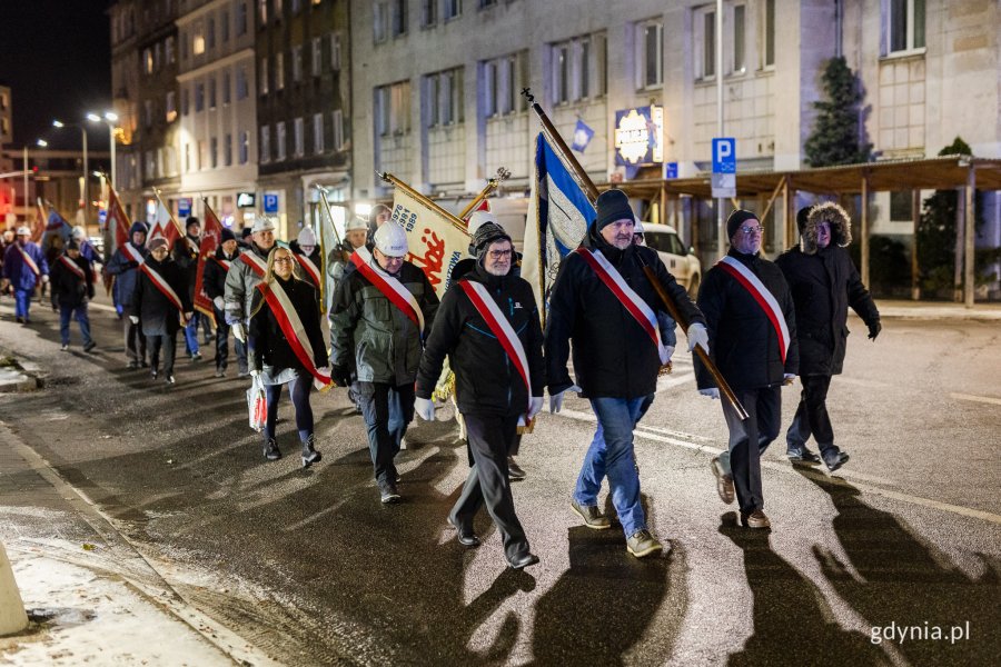 Ludzie w odświętnych strojach idący ulicą