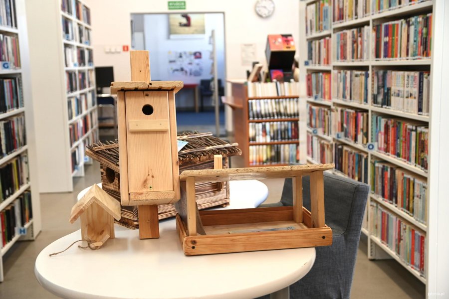 Karmniki i budki na stole w bibliotece