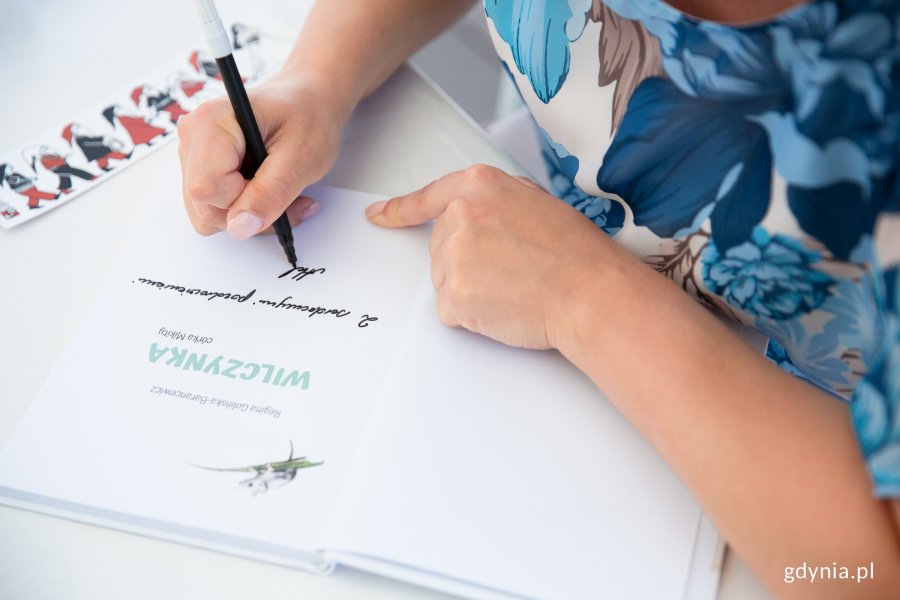 Prezydent Gdyni Aleksandra Kosiorek składa autograf w książce (fot. Natalia Kawalerowicz)