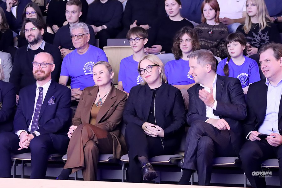 Mężczyźni i kobiety siedzący na krzesłach w auli