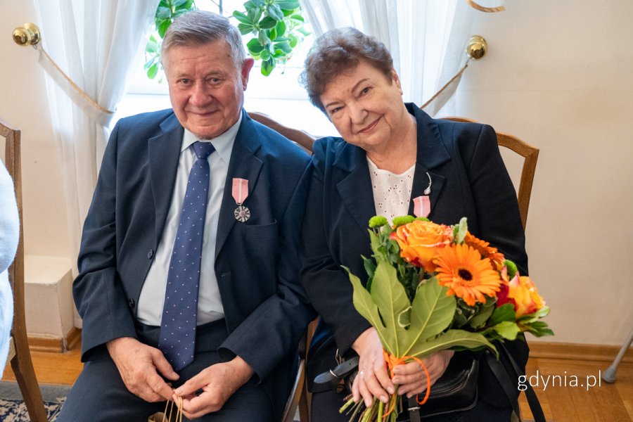 Mężczyzna w garniturze, kobieta z bukietem kwiatów