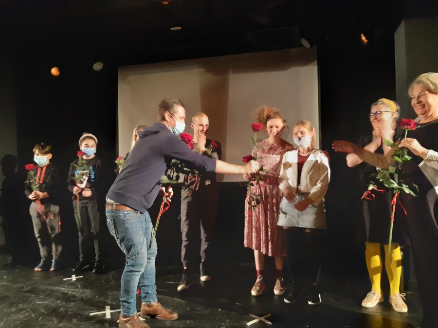 Dzieci ze Szkoły Podstawowej nr 47 i aktorzy na scenie, wręczane im są róże i gratulacje.