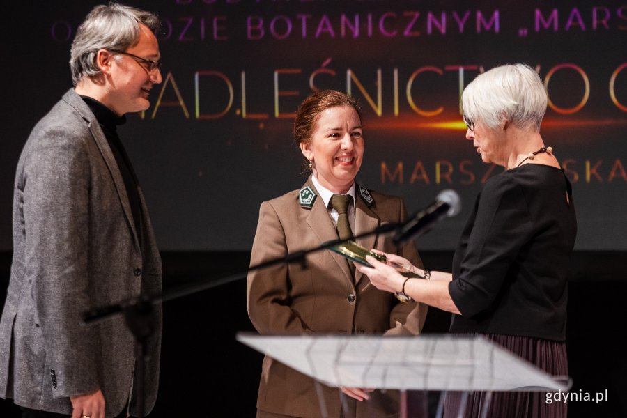 Nagrodę „Czas Gdyni” w kategorii architektura za twórcze rozwiązanie układu brył, konstrukcji i elewacji budynku edukacyjnego w Leśnym Ogrodzie Botanicznym Marszewo otrzymała pracownia projektowa Gierbienis + Poklewski s.c.  Od lewej Damian Poklewski-Koziełł, Ewa Kaliszewska, sekretarz Nadleśnictwa Gdańsk i Przewodnicząca Rady Miasta Joanna Zielińska / fot. Karol Stańczak 