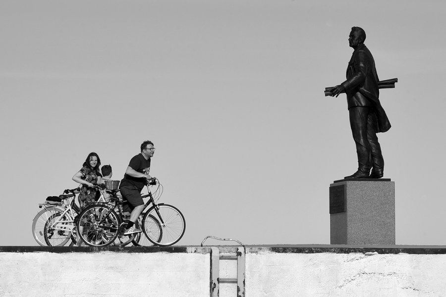 Ludzie na rowerach na przeciwko pomnika Wendy.