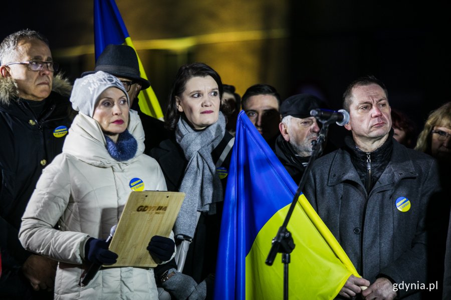 Mieszkańcy Gdyni stoją z flagą Ukrainy podczas uroczystości Gdynia z Wami! Wśród nich wiceprezydent Gdyni Katarzyna Gruszecka-Spychała.