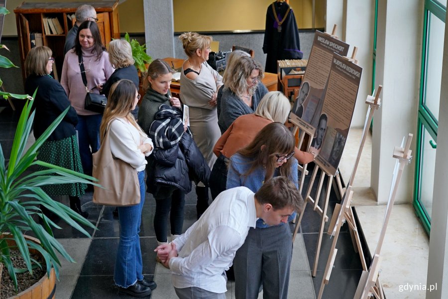 Goście zaproszeni na inaugurację wystawy w sądzie przyglądający się ekspozycji 