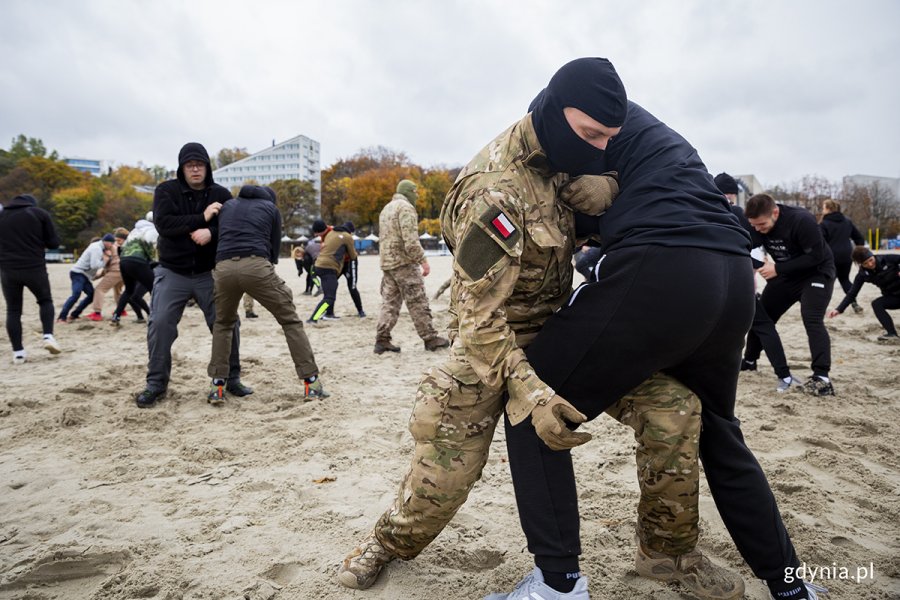 Mieszkańcy ćwiczą na plaży z komandosami.