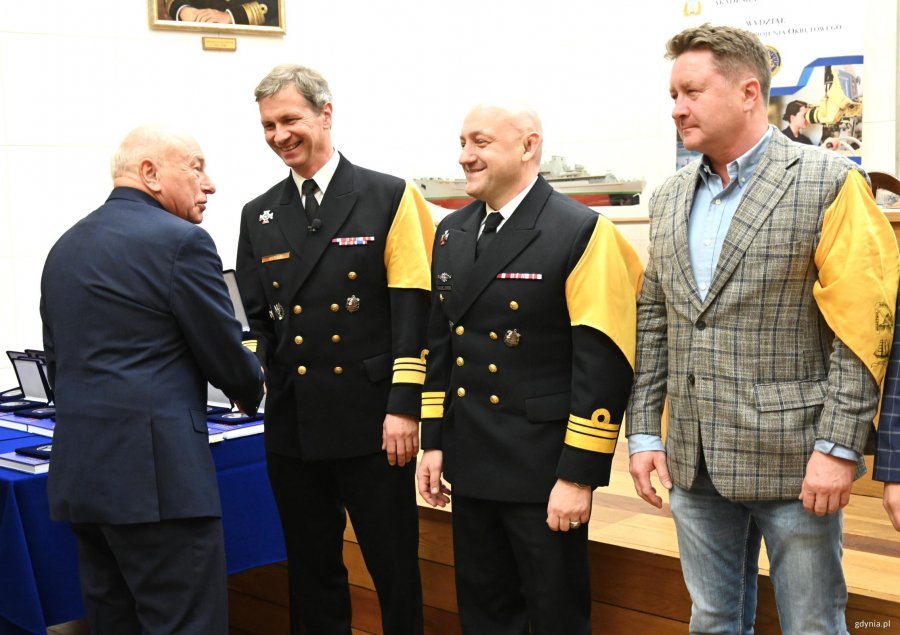 Grupa mężczyn z ż&oacute;łtymi chustami na scenie