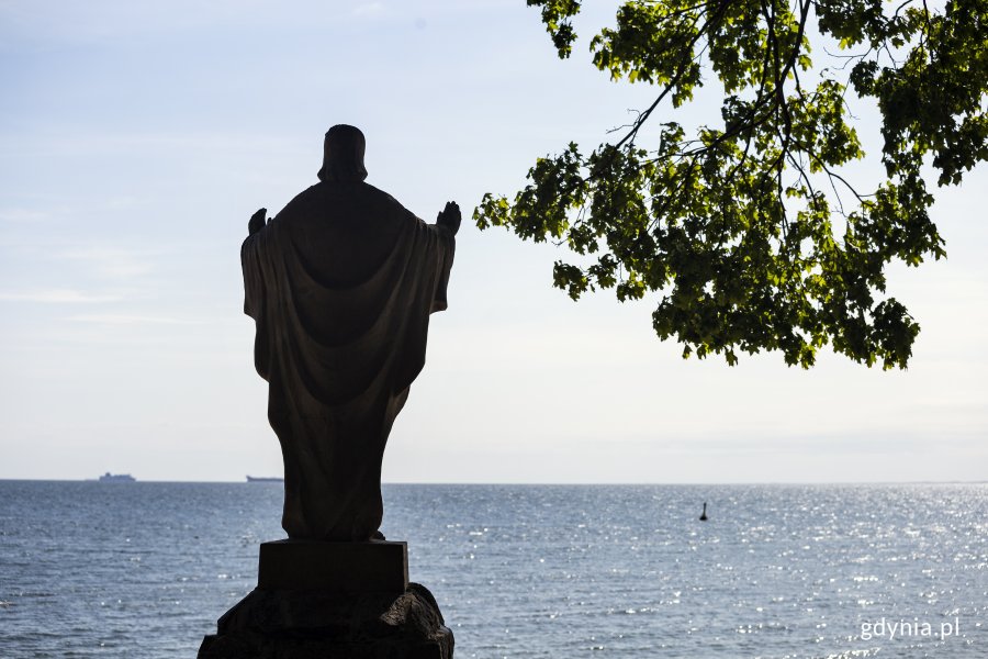 Orłowo. Na pierwszym planie sylweta figury Chrystusa i gałąź drzewa, w tle morze. Fot, Przemysław Kozłowski