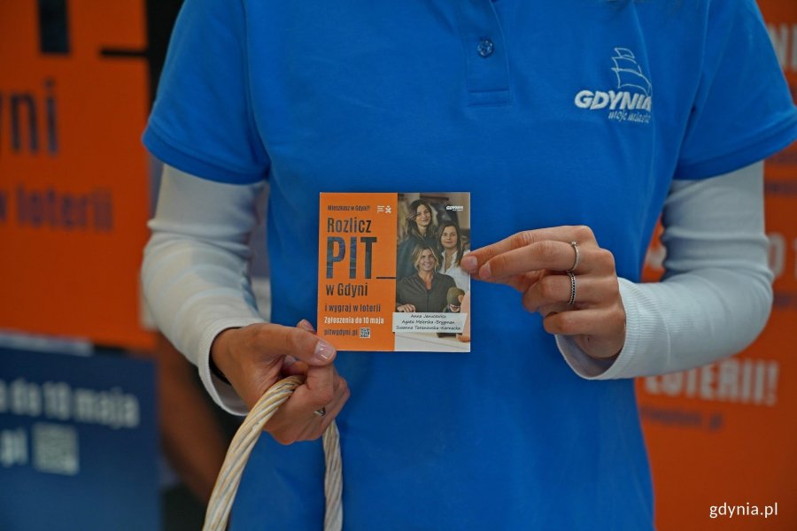 Konsultantka z ulotką informacyjną na temat loterii &bdquo;Rozlicz PIT w Gdyni&rdquo;
