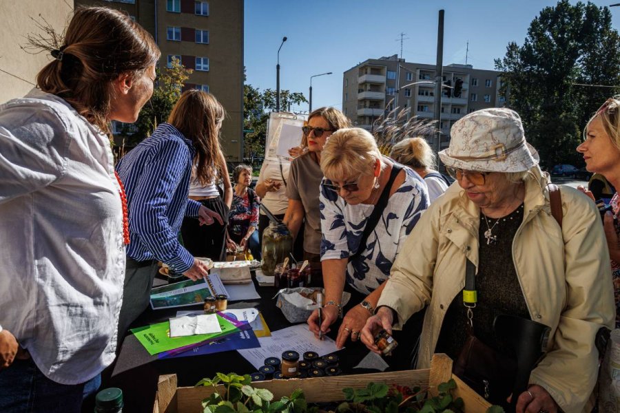 Grupa osób oglądająca przedmioty na stoisku wystawienniczym