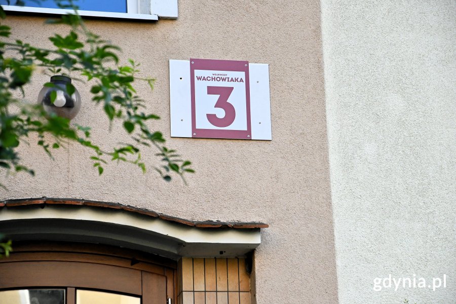 Zdjęcie przedstawia tabliczkę z napisem "Wojewody Wachowiaka 3". To budynek, w którym znajdują się mieszkania komunalne.