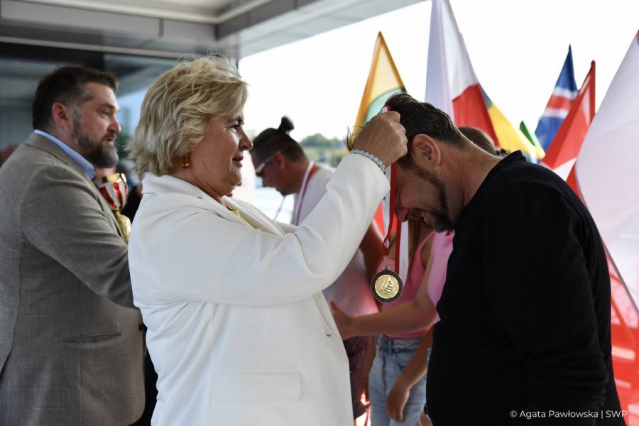 Teresa Bysewska wręcza zawdnikowi medal