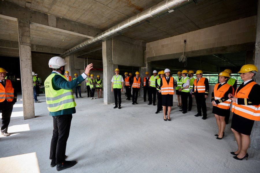 Uczestnicy spaceru po powstającym budynku Centrum Sportu i Rekreacji Uniwersytetu Morskiego. Mają na sobie kamizelki odblaskowe i kaski // fot. Jacek Koślicki / Koslicki.pl