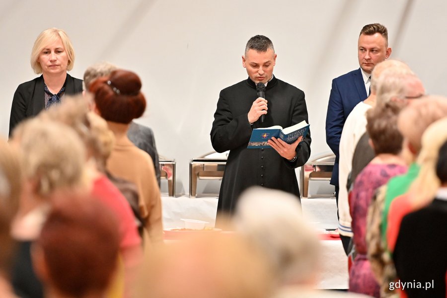 Wigilia dla seniorów w Przystani Chylońska 237, na zdjęciu ksiądz czyta Pismo święte na rozpoczęcie wspólnej Wigilii