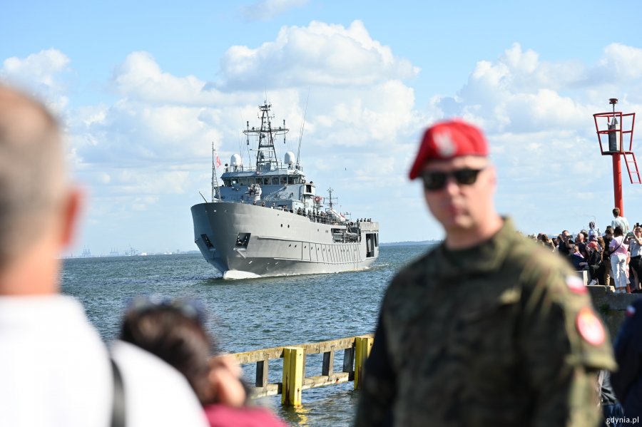 Wojskowy i ludzie obserwujący paradę