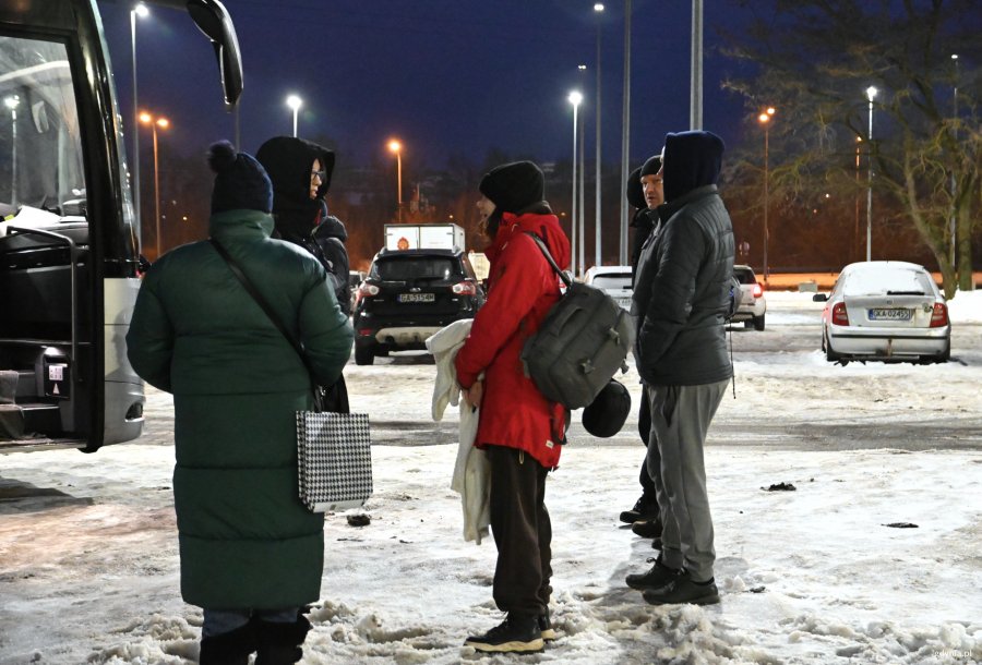 Ciepło ubrani ludzie przed autokarem