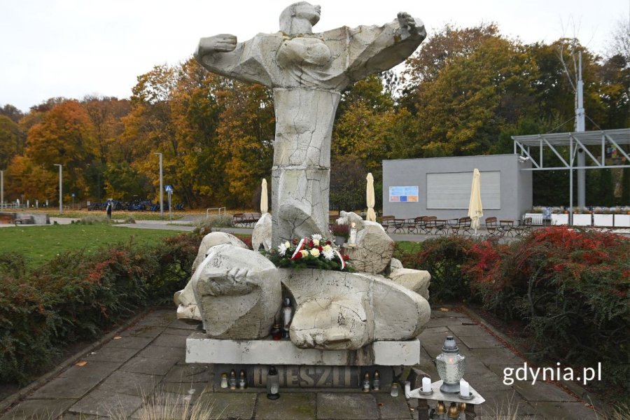 Pomnik z szarych kamieni przedstawiający stojącą kobietę z rozłożonymi rękami
