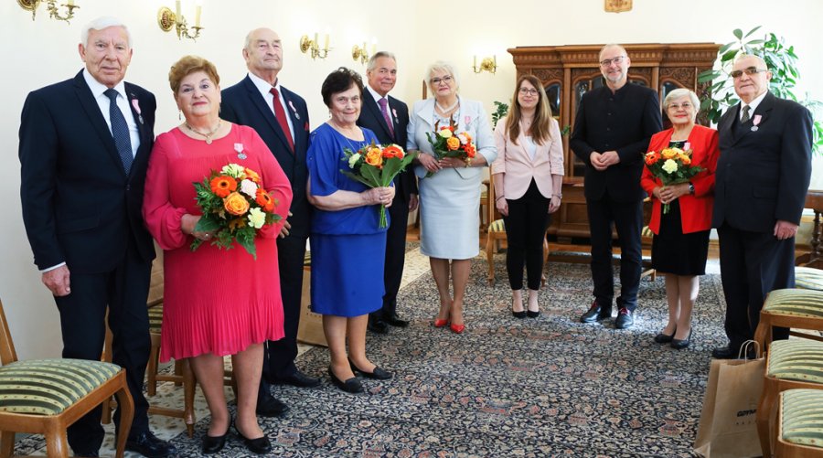 na zdjęciu seniorzy stojący z prezydentem w odświętnej sali 