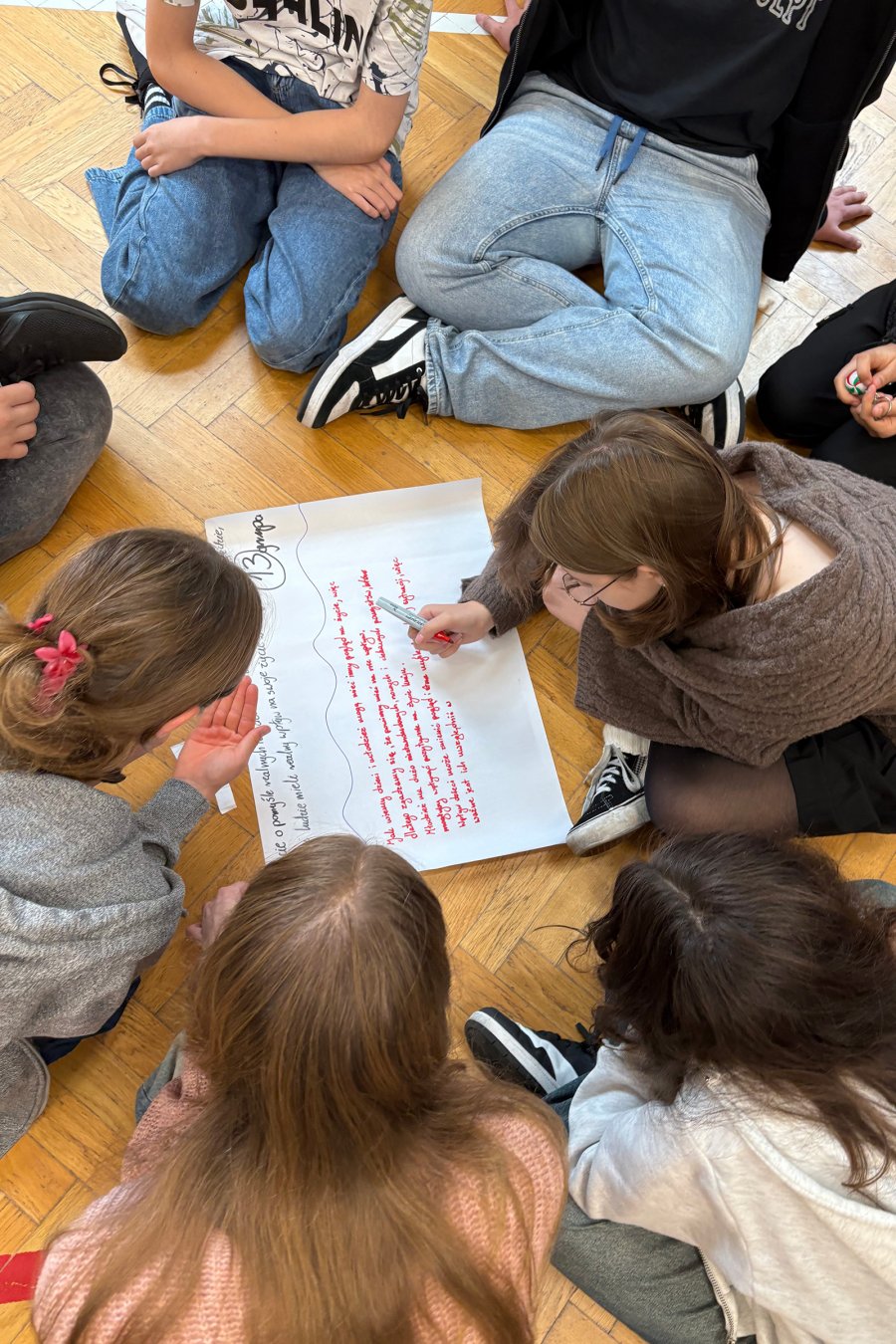 Młodzież leżąca na podłodze w trakcie  debaty poświęconej edukacji obywatelskiej