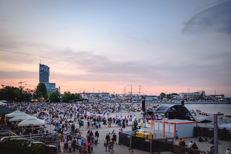 Tłum ludzi na plaży podczas koncertu.