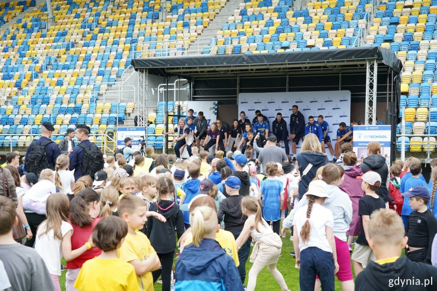 Uczniowie i scena podczas wydarzenia „Rusz się z klasą” na Stadionie Miejskim 
