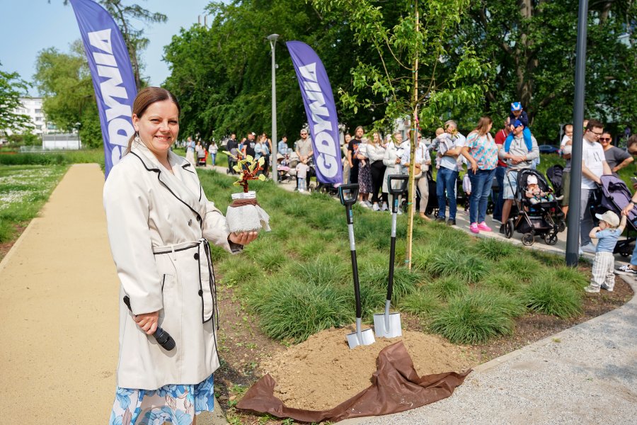 Prezydent Gdyni Aleksandra Kosiorek przy nowym Drzewku Życia w Parku Centralnym. W rękach trzyma słoiczek z imionami dzieci urodzonych w naszym mieści w 2024 roku
