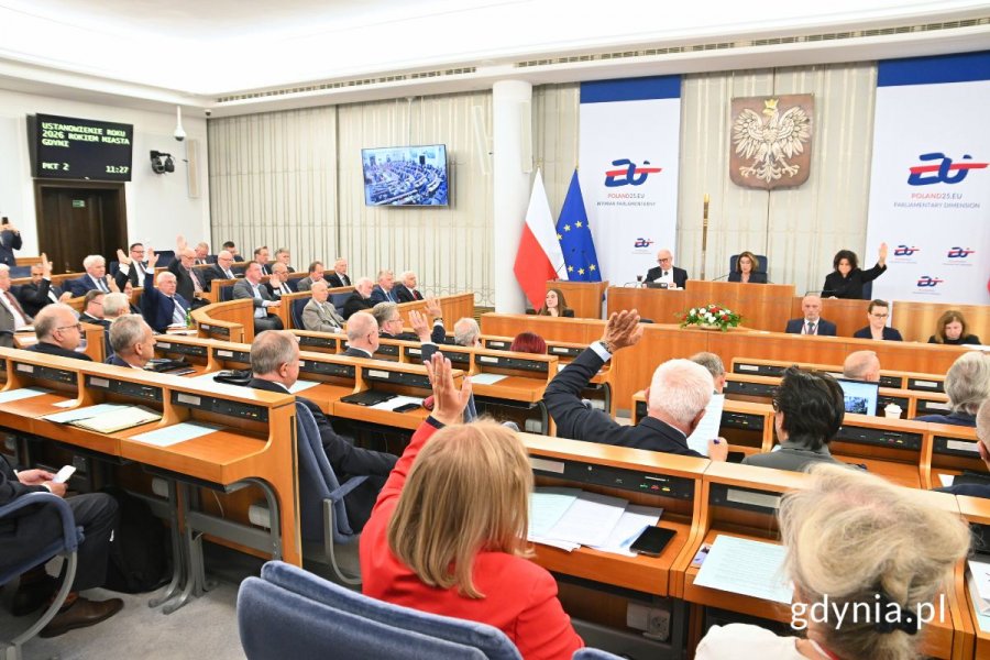 Senatorowie głosujący poprzez podniesienie ręki na sali obrad Senatu