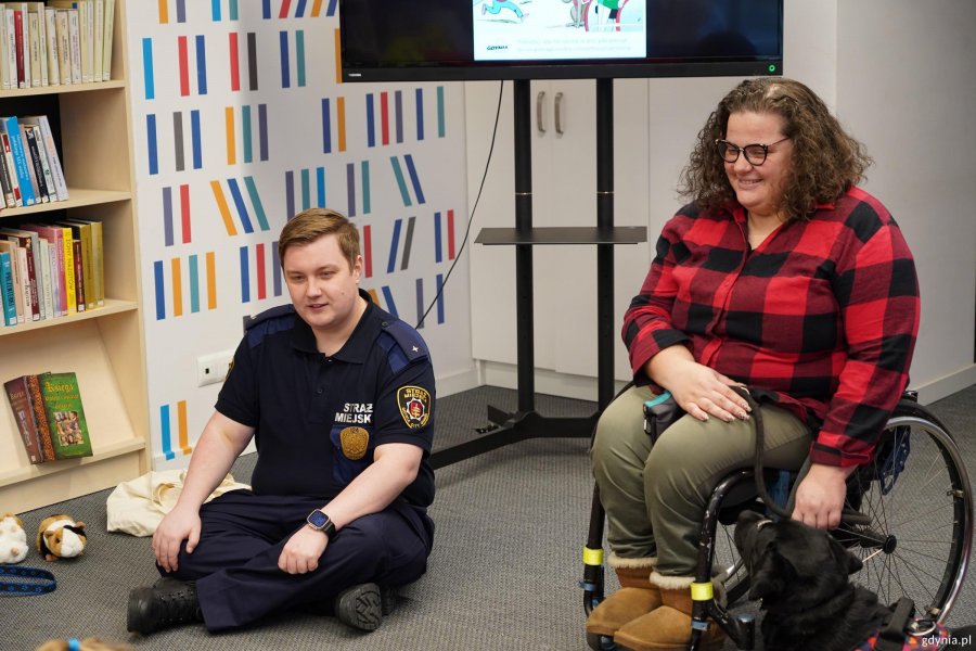 Marta Czachor z Wydziału Dostępności Urzędu Miasta Gdyni i Kamil Zdunek z Wydziału Straży Miejskiej Zarządzania Kryzysowego na spotkaniu z przedszkolakami w Bibliotece Śr&oacute;dmieście