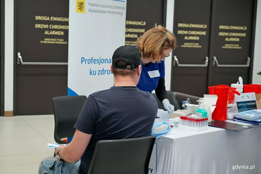 Jeden z uczestnik&oacute;w akcji z okazji Dnia Mężczyzny przy stoisku medycznym na pasażu Centrum Handlowego Riviera