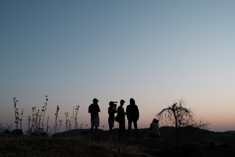 Ekipa filmowa na wzgórzu Tanzanii na tle zachodzącego słońca