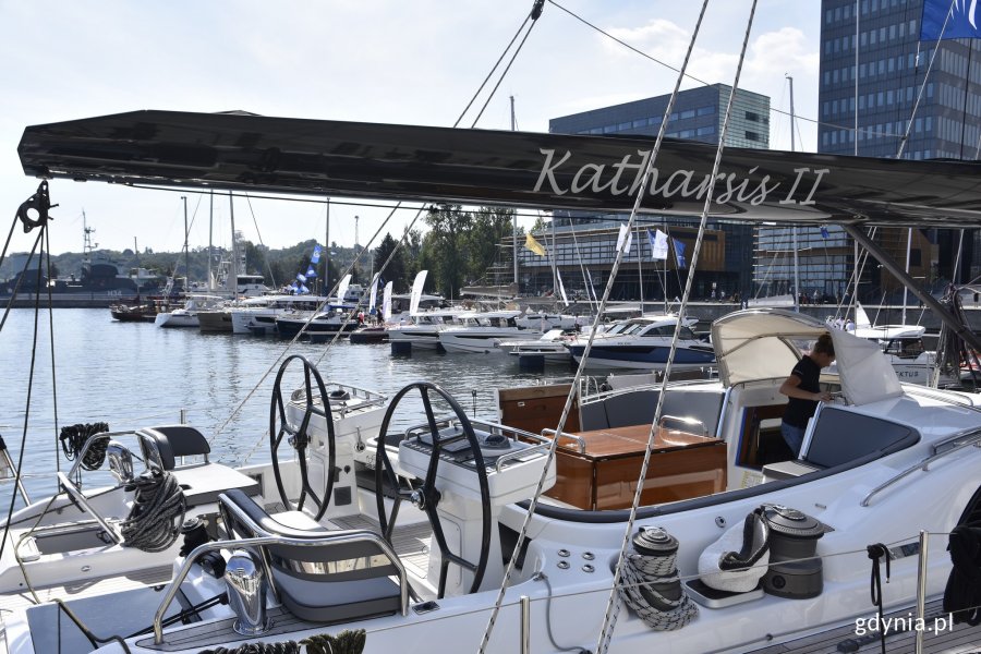 Biały jacht Katharsis II zacumowany przy kei w Marina Yacht Parku w Gdyni. Ma czarny maszt z wypisaną srebrnymi literami nazwą jednostki. W tle inne jachty // fot. Magdalena Czernek