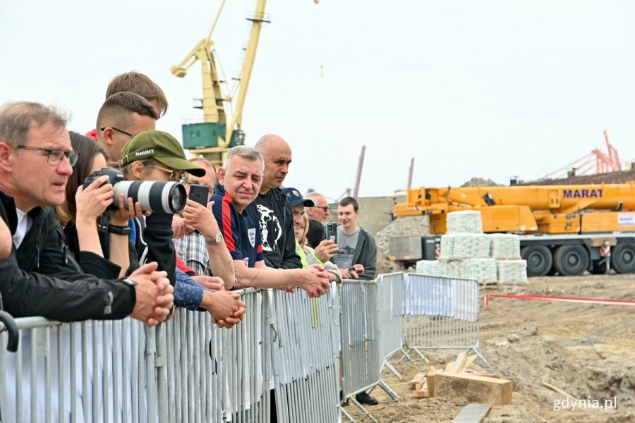 Uczestnicy uroczystości przyglądający się wmurowaniu kapsuły czasu i kamienia węgielnego pod budowę hal stoczniowych na terenie PGZ Stoczni Wojennej // fot. Magdalena Czernek
