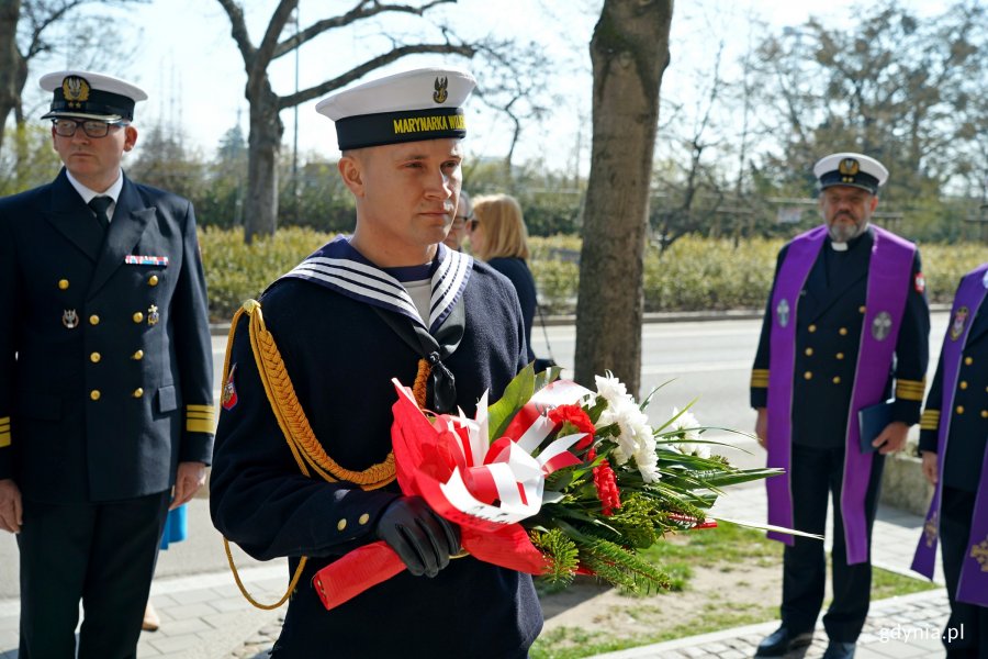 Marynarz z wiązanką kwiatów podczas uroczystości z okazji Dnia Pamięci Ofiar Zbrodni Katyńskiej