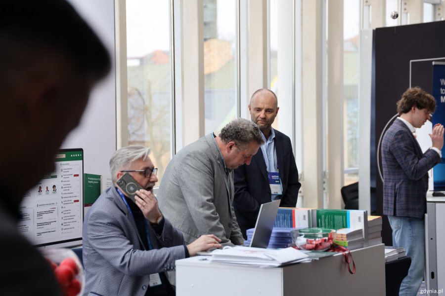 Mężczyźni przy stanowisku na kongresie w Sheratonie