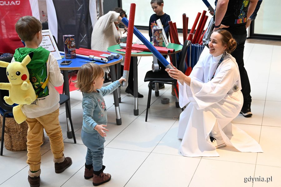 Kobieta w stroju z Gwiezdnych Wojen na finale WOŚP bawi się z dzieckiem.