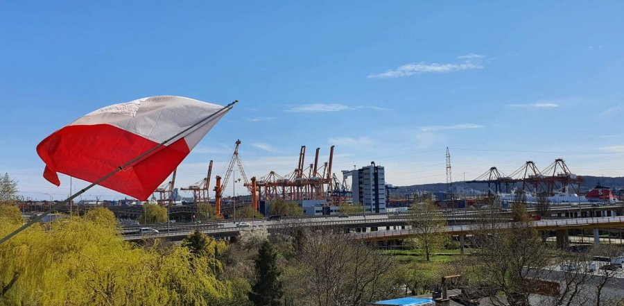 Po lewej stronia biało-czerwona flaga, w tle widać port. // fot. Magdalena Bichta