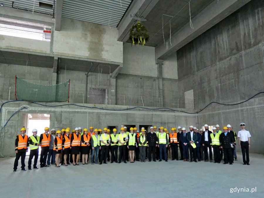 Uczestnicy uroczystości stojący pod wiechą podniesioną na budowie Centrum Sportu i Rekreacji Uniwersytetu Morskiego w Gdyni // fot. Magdalena Czernek
