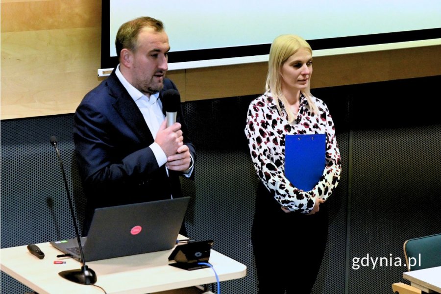 Mężczyzna i kobieta stojący za pulpitem z laptopem