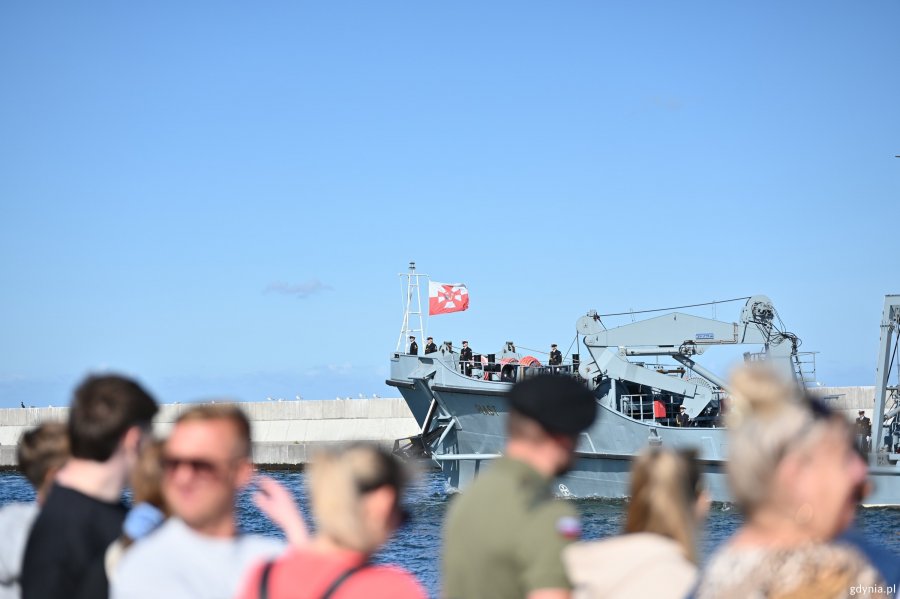 Ludzie fotografują przepływający okręt