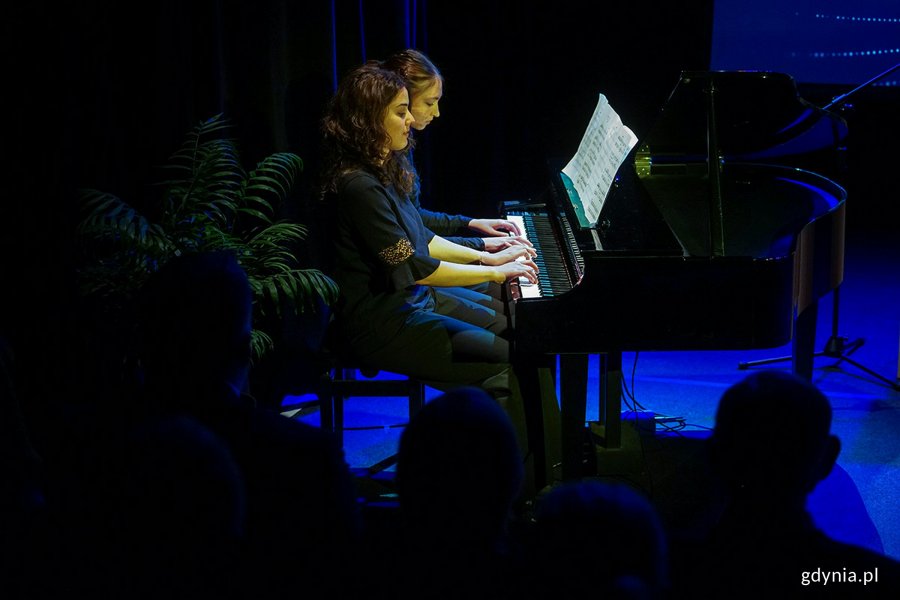 Emilia Sandecka i Zofia Pałasz, uczennice Szkoły Muzycznej I i II stopnia w Gdyni, grające na cztery ręce na fortepianie podczas uroczystości w Konsulacie Kultury