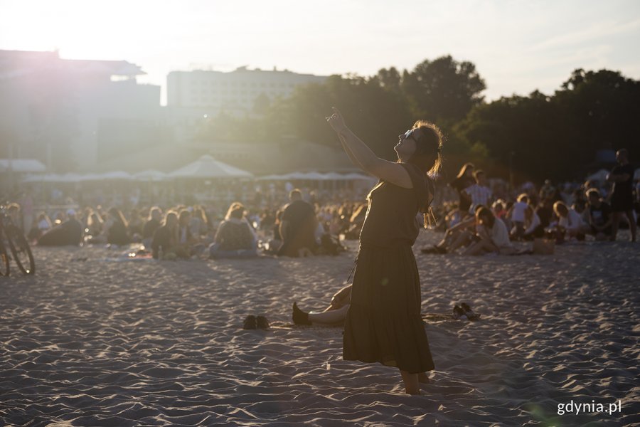 Kobieta tańczy na plaży.