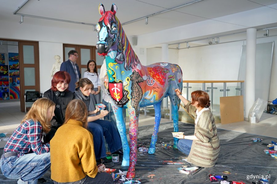 Uczniowie Państwowego Liceum Sztuk Plastycznych w Gdyni malujący rzeźbę konia, kt&oacute;rą miasto przekaże na licytację WOŚP 
