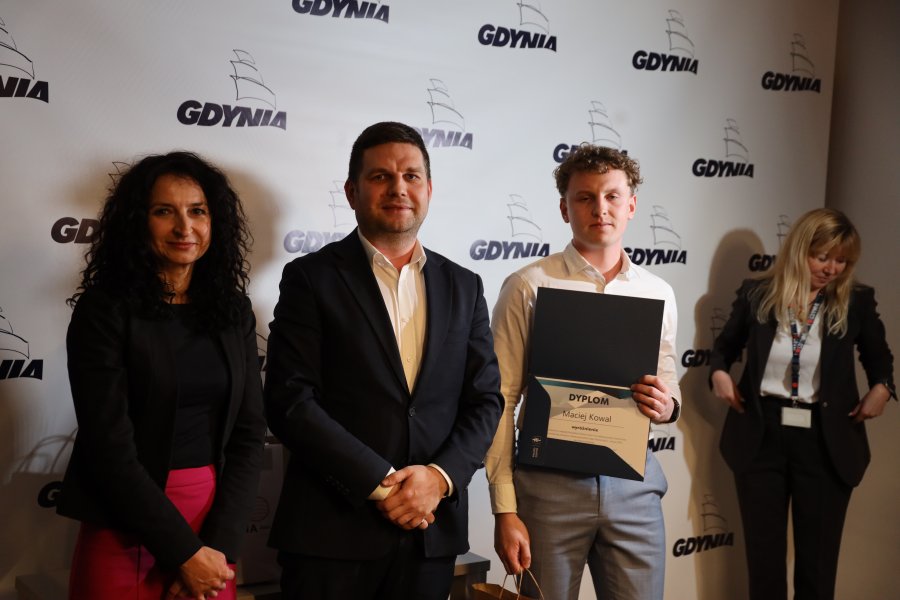 Wiceprezydent Gdyni Maciej Zielonka wręcza wyróżnienia i pamiątki laureatom