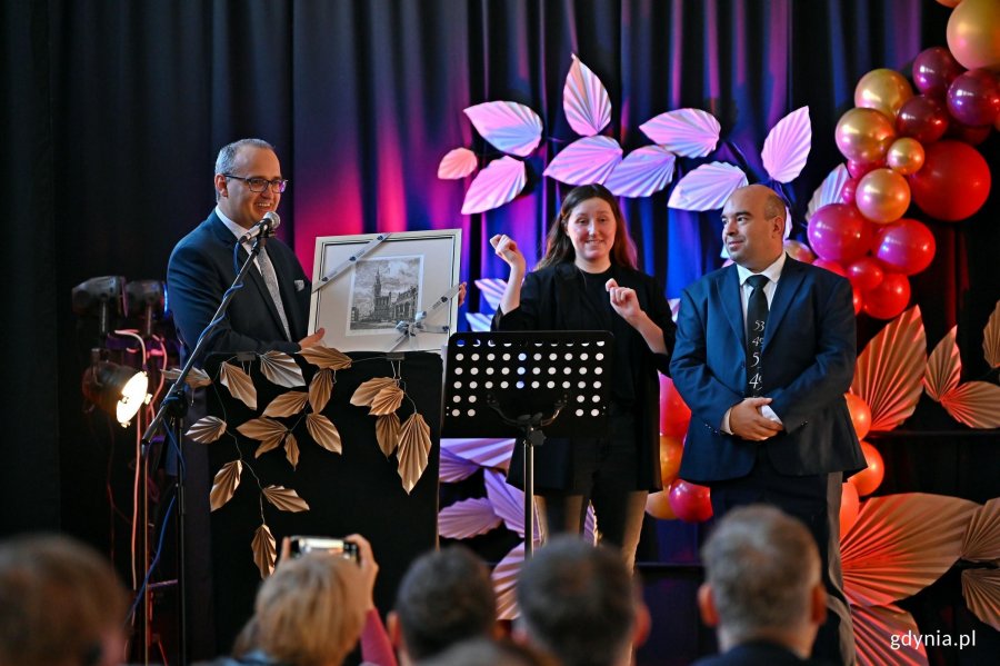 Wicewojewoda pomorski Emil Rojek przekazujący rycinę Mariuszowi Kowalczykowi &ndash; dyrektorowi Zespołu Szk&oacute;ł Og&oacute;lnokształcących nr 6 podczas uroczystości z okazji jubileuszu 40-lecia Szkoły Podstawowej nr 49 dla Dzieci Niedosłyszących