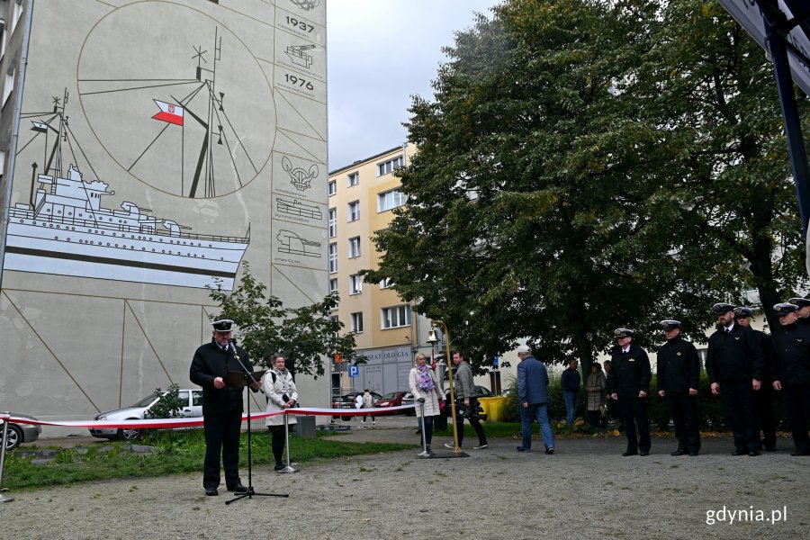 Przy mikrofonie przemawia kmdr por. Paweł Ogórek - dowódca okrętu ORP "Błyskawica". Po prawej część marynarzy z "Błyskawicy". W tle mural prezentujący słynny okręt // fot. Magdalena Czernek