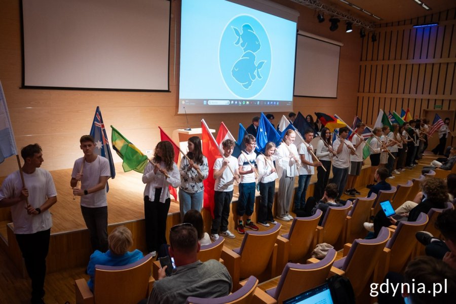 Młodzież stojąca z flagami przed sceną 