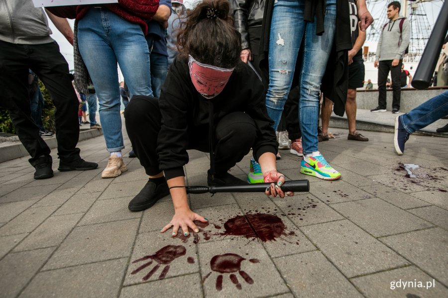 Uczestniczka akcji "Stop przemocy wobec narodu Białorusi" odciska na chodniki krwawe ślady rąk // fot. Karol Stańczak