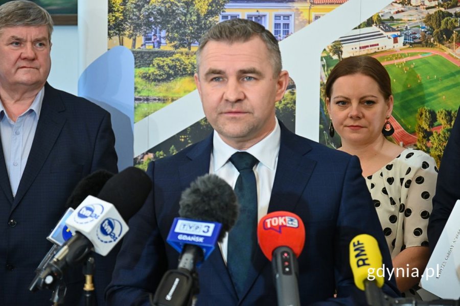 Michał Pasieczny, burmistrz Rumi stojący przed mikrofonami